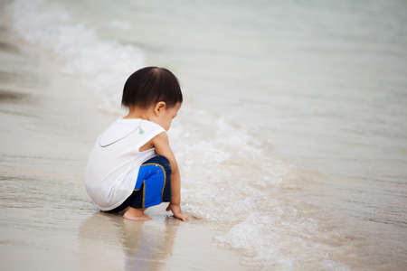 Child playing alone on the beachの写真素材