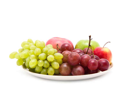 Apple and grape fruits on dish, isolated on white backgroundの写真素材
