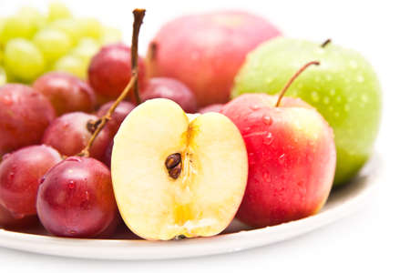 Apple and grape fruits on white dishの写真素材