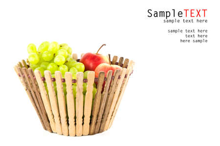 Apple and grape fruits in wood basket on white backgroundの写真素材