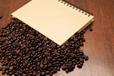 Coffee beans and book on wooden backgroundの写真素材