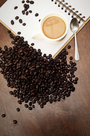 Coffee cup and beans on the bookの写真素材