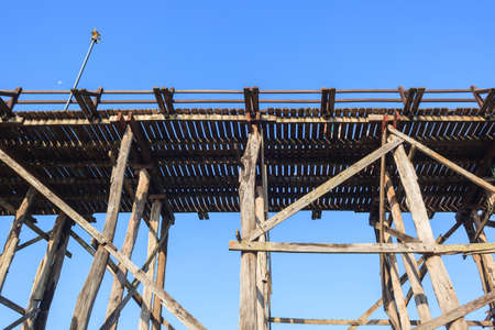 Old wooden bridge against blue sky backgroundの写真素材