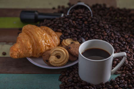 White coffee cup and cookies with beans backgroundの写真素材