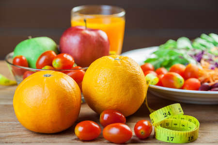 Healthy concept with mixed fruits and vegetables on wooden background