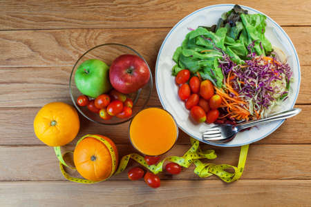 Healthy concept with mixed fruits and vegetables on wooden backgroundの写真素材