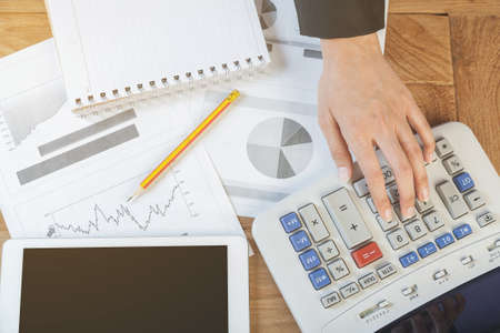 Business woman putting her hand on calculator, business and investment concept