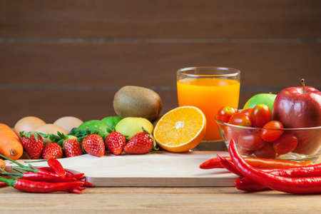 Healthy concept with mixed fruits and vegetables on wooden backgroundの写真素材