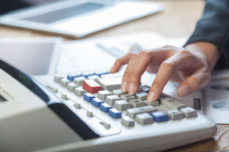 Business woman putting her hand on calculator, business and investment conceptの写真素材
