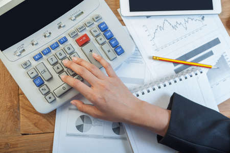 Business woman putting her hand on calculator, business and investment concept