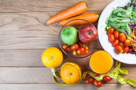 Fresh healthy salad with different fruits and vegetables on wooden backgroundの写真素材