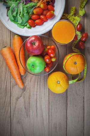 Fresh healthy salad with different fruits and vegetables on wooden backgroundの写真素材
