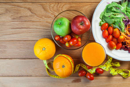 Healthy concept with mixed fruits and vegetables on wooden backgroundの写真素材