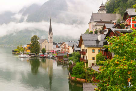 Scenic view of famous Hallstatt mountain village in the Austrian Alps with misty raining, Salzkammergut region, Austriaの写真素材