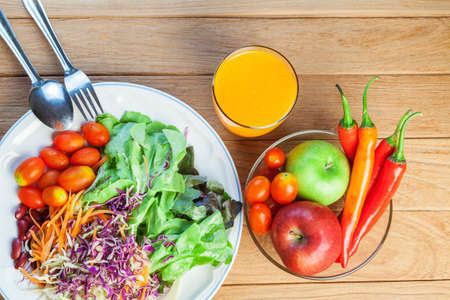 Healthy concept with mixed fruits and vegetables on wooden backgroundの写真素材