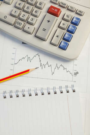 Investment charts with laptop and calculator on wooden table workplaceの写真素材