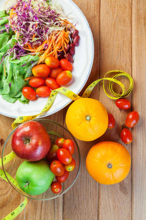 Healthy concept with mixed fruits and vegetables on wooden backgroundの写真素材