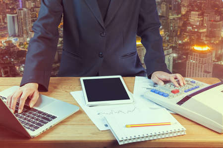Business woman putting her hand on calculator, business and investment conceptの写真素材