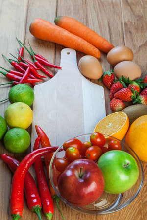 Healthy concept with mixed fruits and vegetables on wooden backgroundの写真素材