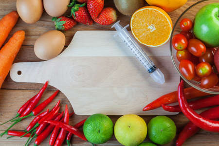 Healthy concept with mixed fruits and vegetables on wooden backgroundの写真素材