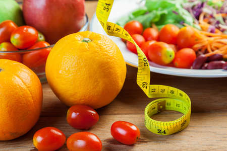 Healthy concept with mixed fruits and vegetables on wooden backgroundの写真素材