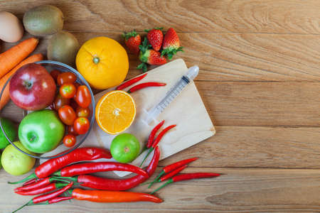 Healthy concept with mixed fruits and vegetables on wooden backgroundの写真素材