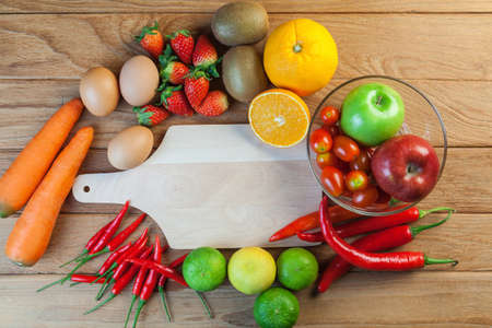 Healthy concept with mixed fruits and vegetables on wooden backgroundの写真素材