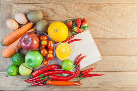 Healthy concept with mixed fruits and vegetables on wooden backgroundの写真素材