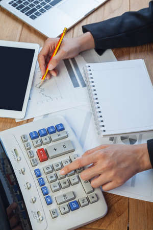 Business woman putting her hand on calculator, business and investment conceptの写真素材