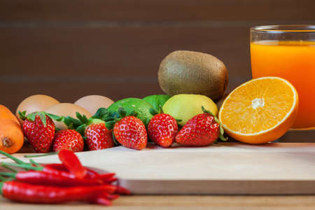 Healthy concept with mixed fruits and vegetables on wooden backgroundの写真素材