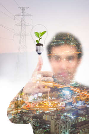Double exposure of business man with green plant in light bulb, energy saving conceptの写真素材