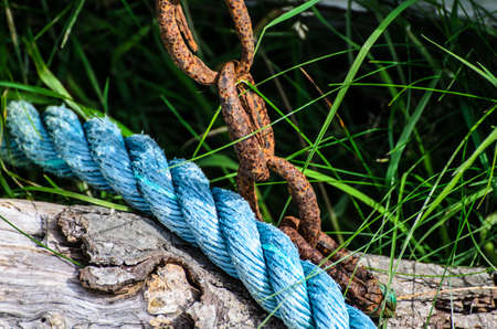 old and decayed mooring line on shore の写真素材