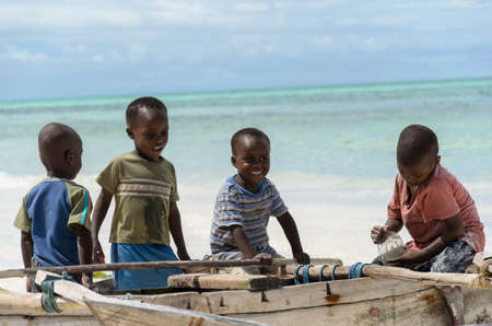 TANZANIA, ZANZIBAR: MARCH 26 2013: young happy african boys on fishing boat waiting for parentsのeditorial素材