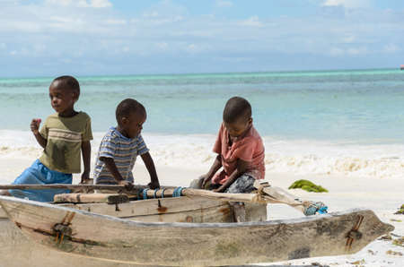 TANZANIA, ZANZIBAR: MARCH 26 2013: young happy african boys on fishing boat waiting for parentsのeditorial素材