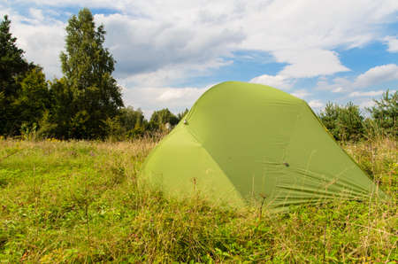 pitched tent in meadow on sunny day の写真素材