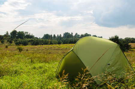 pitched tent in meadow on sunny day の写真素材