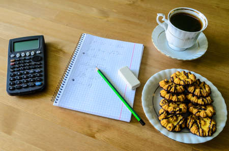 workplace, study place with calculator, workbook, cup of coffee and cookies - stock photoの写真素材