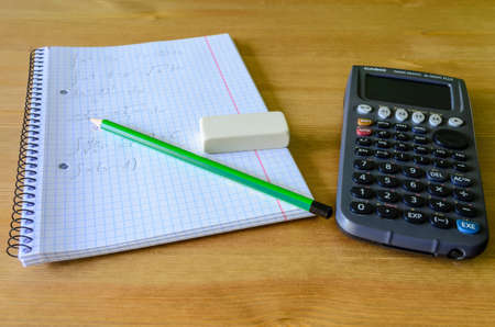 workplace, study place with calculator, workbook and pencil の写真素材