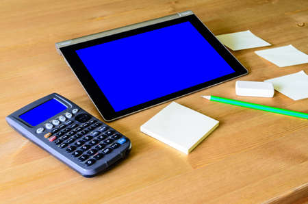 workplace with tablet pc - blue box, calculator, pencil and sticky notes の写真素材