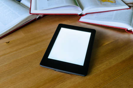 lightweight e-book (electronic reader) compared to heavy thick books - stock photoの写真素材