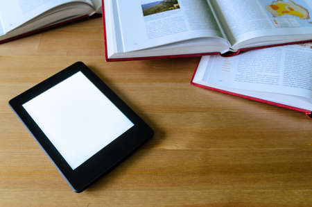 lightweight e-book (electronic reader) compared to heavy thick books - stock photoの写真素材