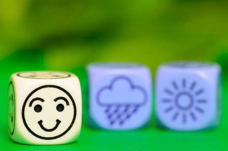 concept of summer weather - emoticon and weather dice on green background - stock photoの写真素材