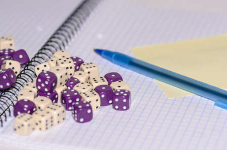 open exercise book with sticky card, pen and dices - stock photoの写真素材
