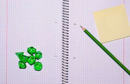 open exercise book with sticky card, pencil and role playing dices - stock photoの写真素材