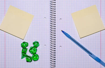 open exercise book with sticky card, pen and role playing dices - stock photoの写真素材