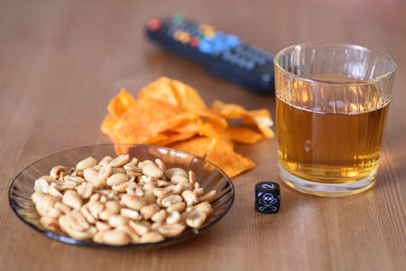 unhealthy snacks on table with skull dice and tv remote  stock photoの写真素材