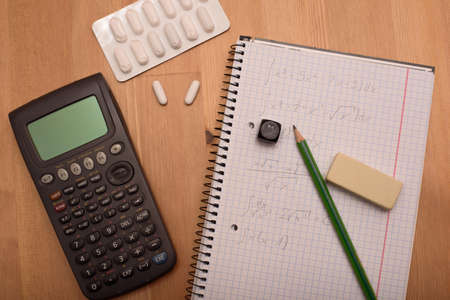 study place with calculator and painkillers in backgroundの写真素材