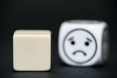 blank dice with emoticon dice (happy) in background の写真素材