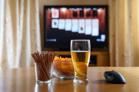 playing card game on big TV screen with snacks&alcohol - stock photoの写真素材