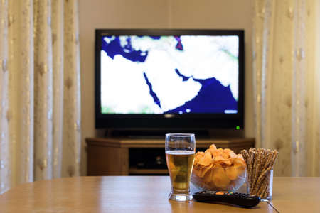 TV, television watching (map of near east, news) with snacks lying on the table - stock photoの写真素材